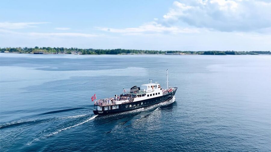 All About the Fjords, in one tour by boat & bus from Ålesund - Hellesylt: cafés, shops, and a waterfall that runs through town